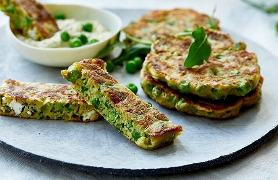 Pea fritters on a plate, shot from the side.
