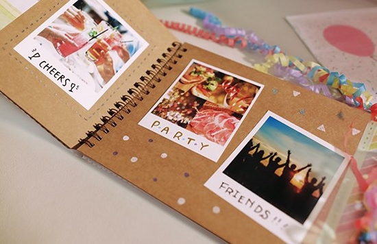 A scrapbook on a table filled with instant camera prints. 