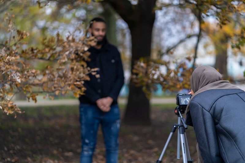 A couple standing in the woods, captured on the touchscreen of a Canon EOS M6 Mark II attached to a tripod.
