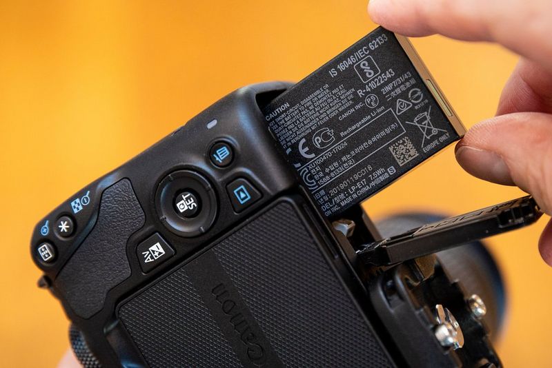 A battery being inserted into a Canon EOS 250D.