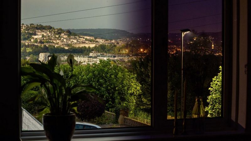 A composite image representing a time-lapse of the scene through a window from day to night.