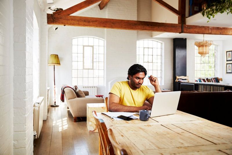 An image of a young man looking at his laptop