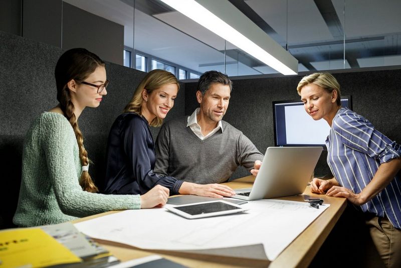 Business people in an office looking at a laptop