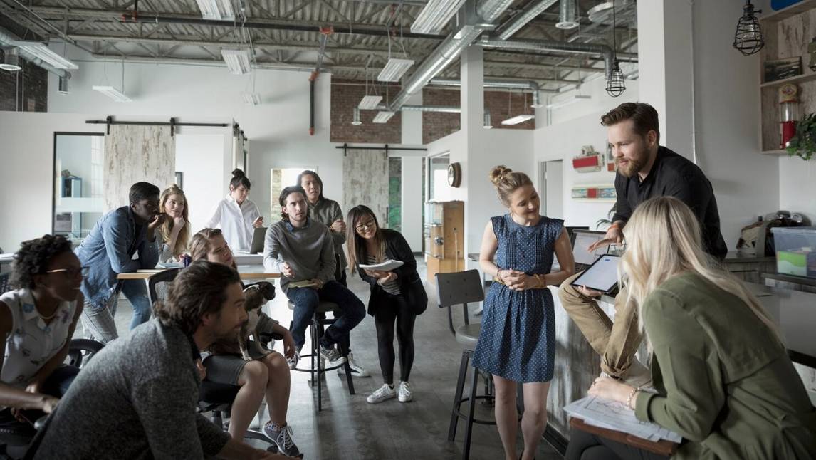 Group of colleagues in a meeting, looking at iPad