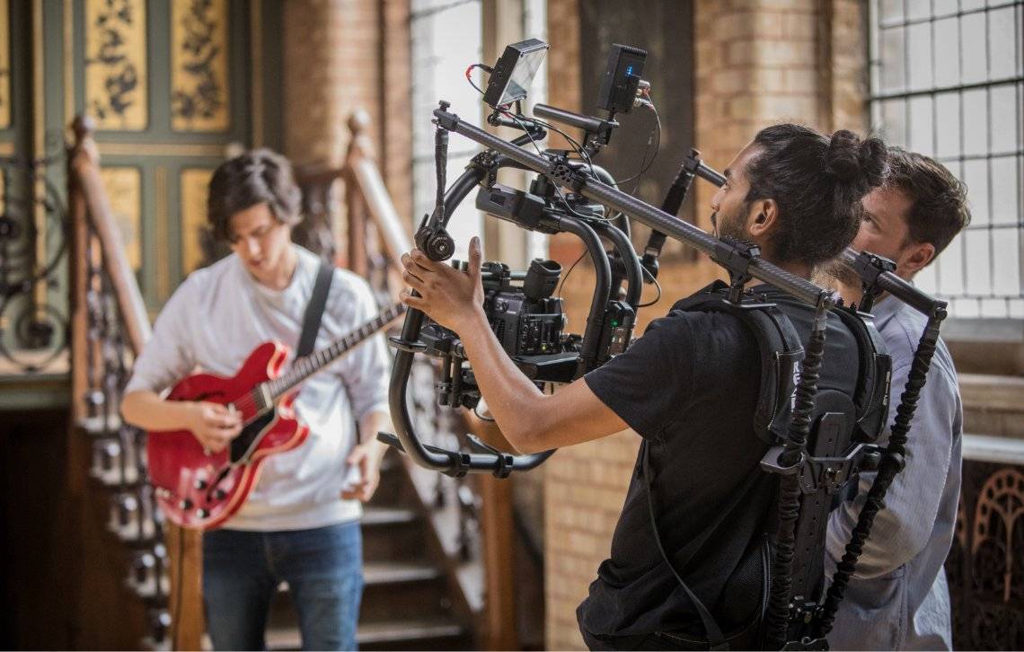 Canon video camera in action whilst filming ricky patel with his guitar. 