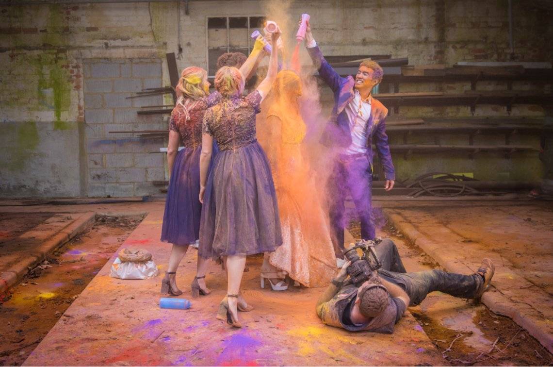 Group of people pouring coulored powder on a woman.