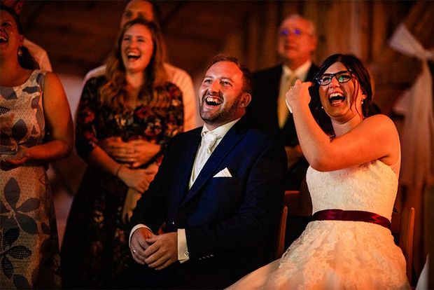 A bride and groom sat together and laughing.