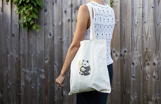 A woman carries a tote bag which has been customised with a panda motif from Creative Park with Canon's iron-on transfers.