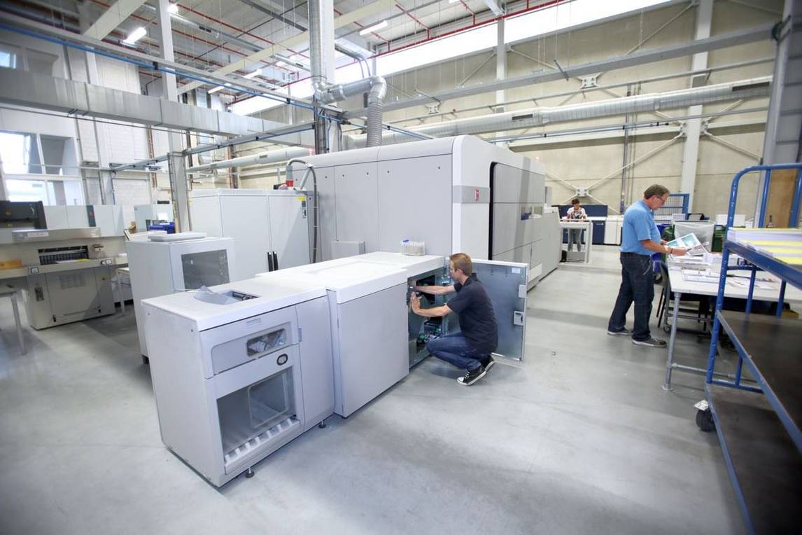 Two men working at digital printing machine