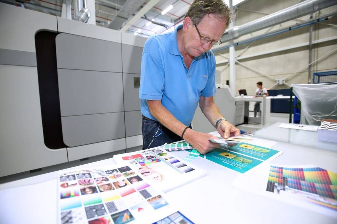 Man examines colour digital prints for book printing