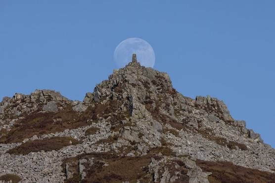 The moon rising over Manstone Rock on the Stiperstones ridge in Shropshire, UK