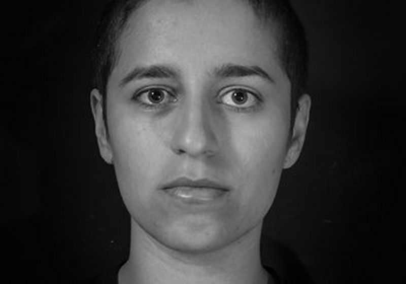 A black and white portrait of Niga Salam with her head shaved.