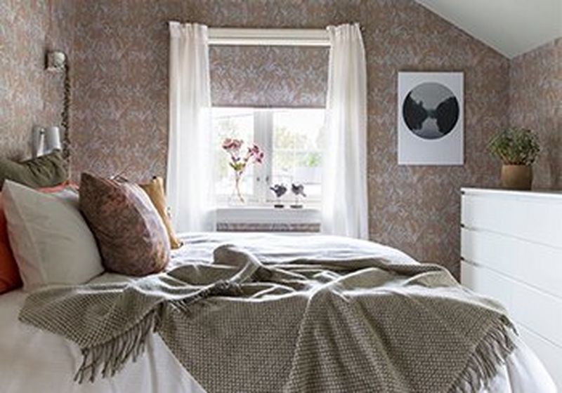 A recreated 18th century wallpaper with patterns of Lily of the Valley is used in a modern bedroom interior.