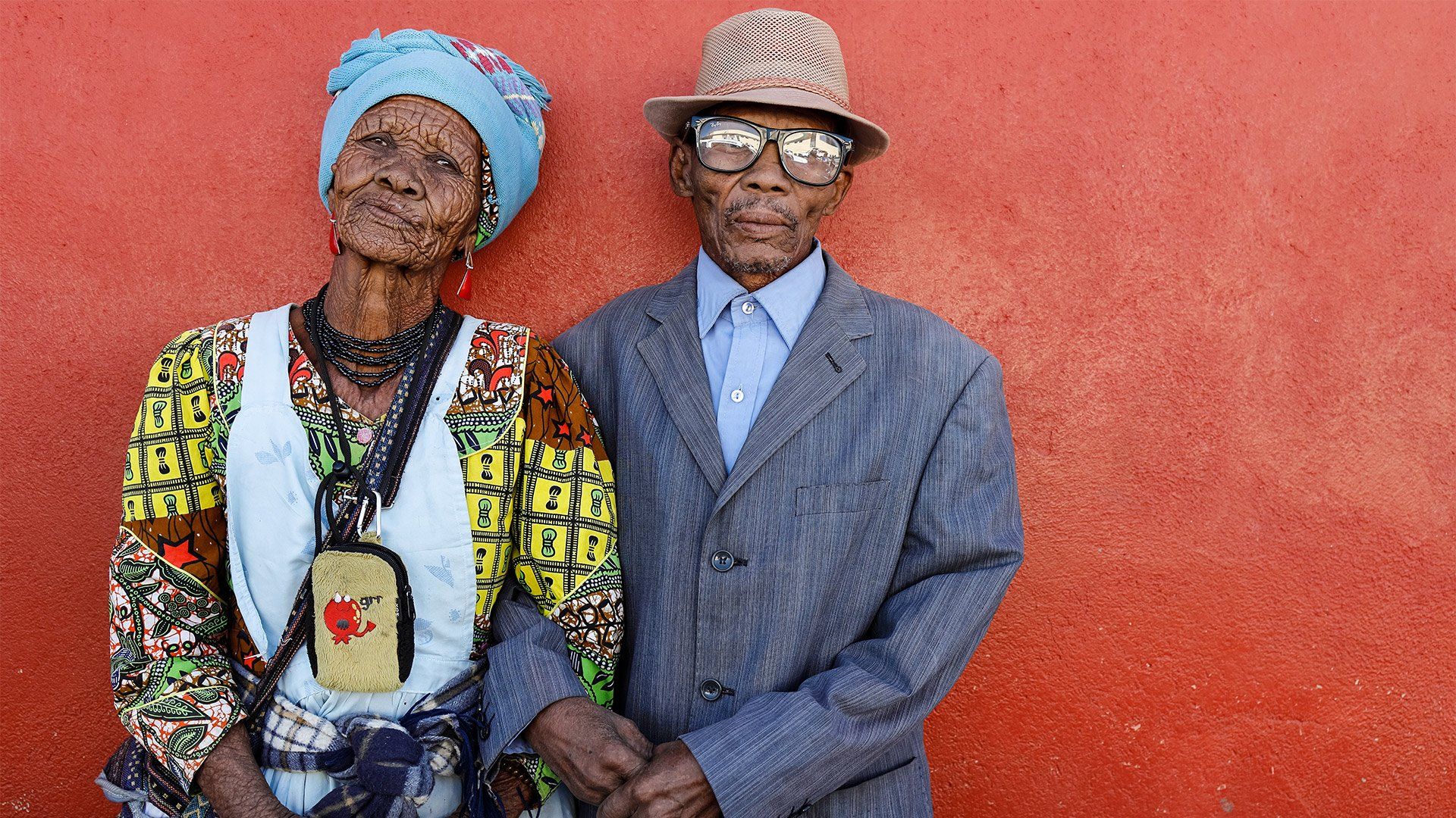 Older African couple against a red wall shot on Canon EOS R & RF 35mm F1.8 MACRO IS STM