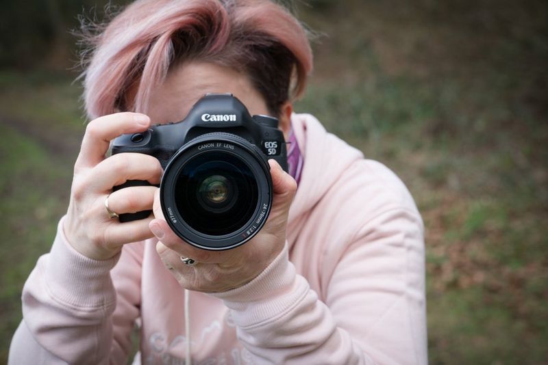 Holding a camera close to your face or body, providing support.