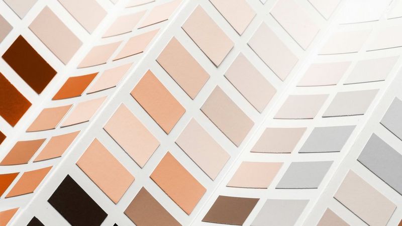 A folding colour swatch chart of grey, peach and taupe tones, darkening down to browns, oranges and black.