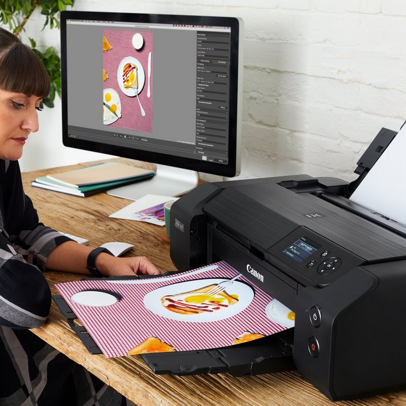 Фотограф забирает яркий цветной отпечаток из принтера Pixma Pro-200