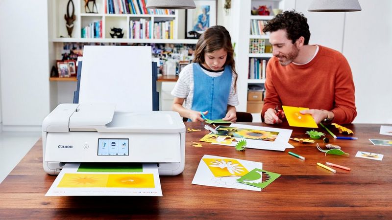 A father helps his daughter make greeting cards out of photographs printed with PIXMA TS 9551C.