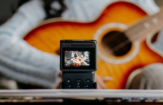 Vlogger Matt Adlard sat at a kitchen table filming a video on the EOS M50 Mark II.