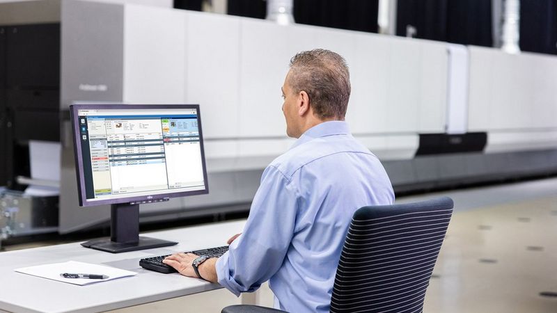 Work professional sitting at he's desk working on he's computer