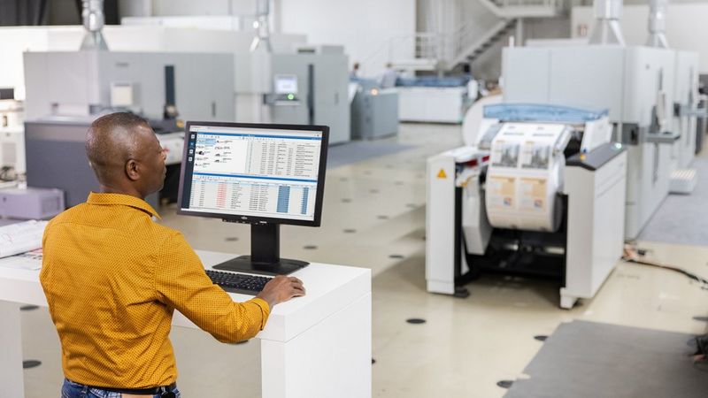 Mn working on his computer in a print room