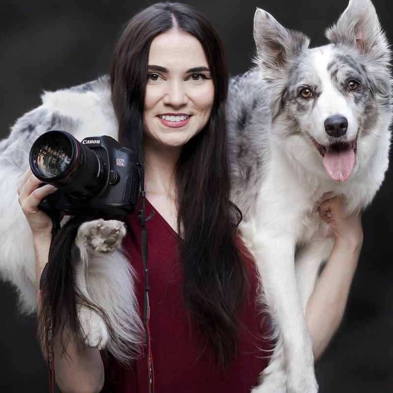 A headshot of Canon Ambassador Alicja Zmysłowska holding a Canon camera, with a dog on her shoulders.