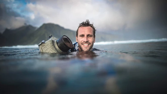 A headshot of Canon Ambassador Benjamin Thouard holding a camera in the water.