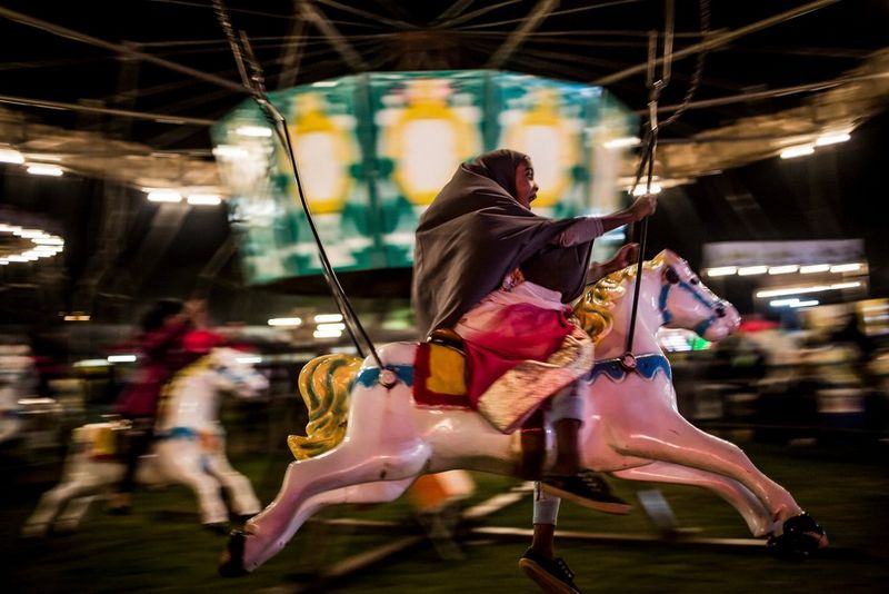 Une jeune fille musulmane crie de joie assise sur un cheval dans un manège lors d'une fête à Johannesburg, en Afrique du Sud.