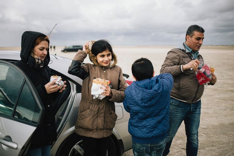Une famille partage des sandwiches à côté de leur voiture dans les marais.