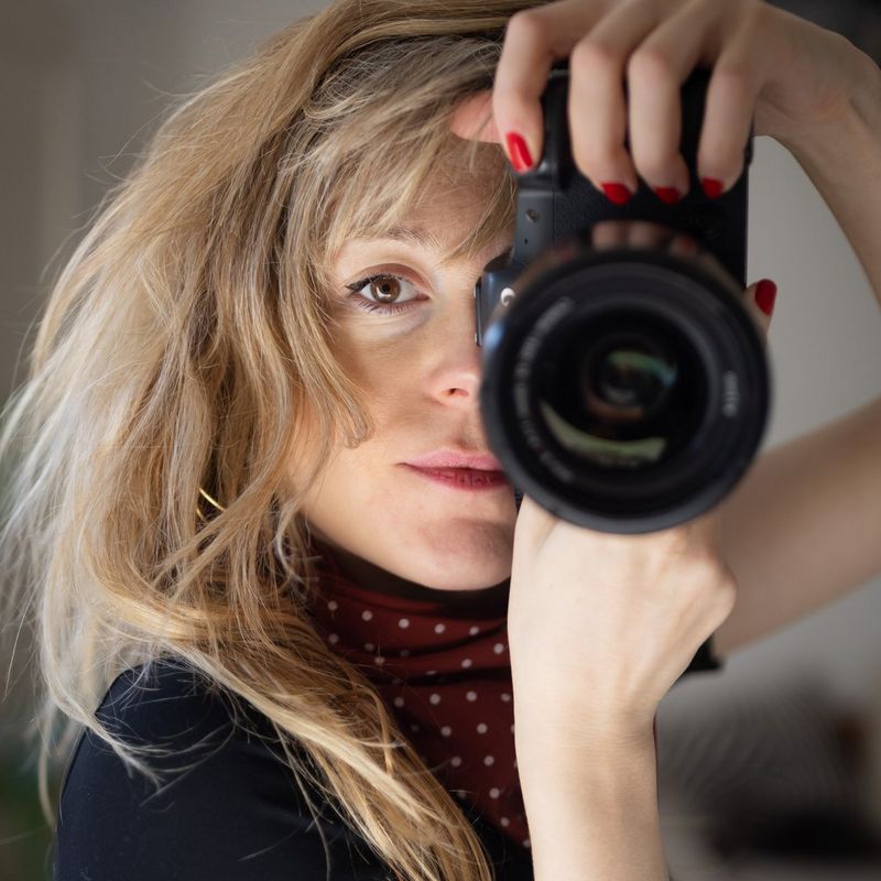 A headshot of Canon Ambassador Laurence Geai, holding a Canon camera to her eye.