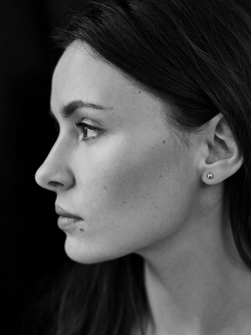 Une mannequin tourne la tête sur le côté sur cette photographie en noir et blanc.