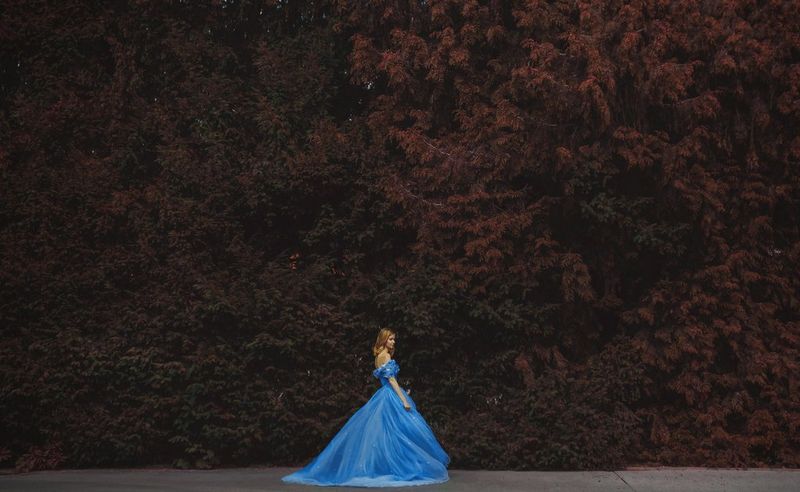 Un modèle, vêtu d'une robe bleue à la Cendrillon, se tient dans le théâtre verdoyant du Jardin royal du château de Prague, en République Tchèque.