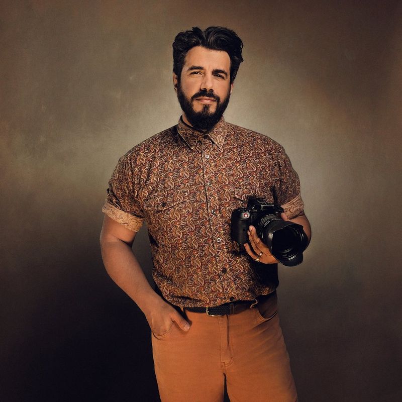 A portrait of Canon Ambassador Sébastien Salamand, known as 'Le Turk', holding a Canon camera. 