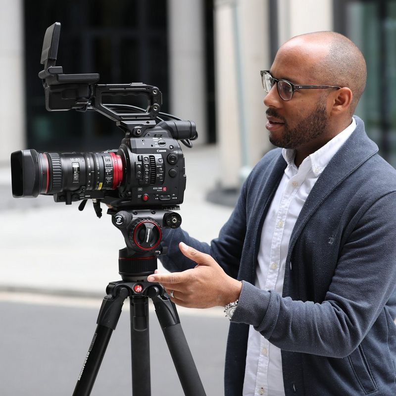 Canon Ambassador Simeon Quarrie standing behind a Canon camera on a tripod.