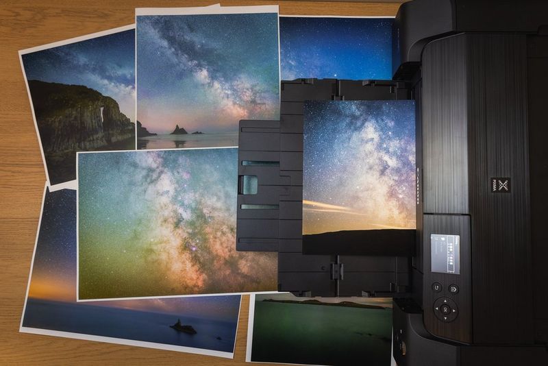 A selection of astrophotography prints surrounding and emerging from a Canon printer 