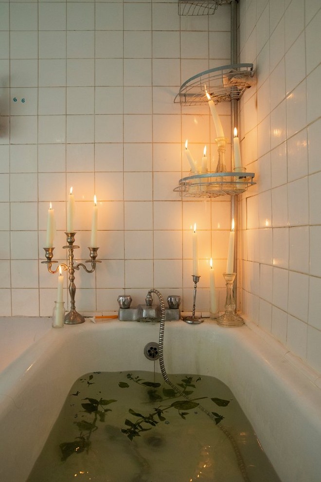Le foglie galleggiano in una vasca da bagno decorata con candelabri accesi in una foto scattata da Wanda Martin.