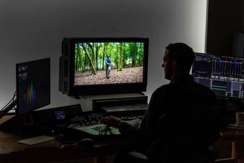 Un ordinateur dans une suite de montage vidéo avec deux écrans de référence HD.