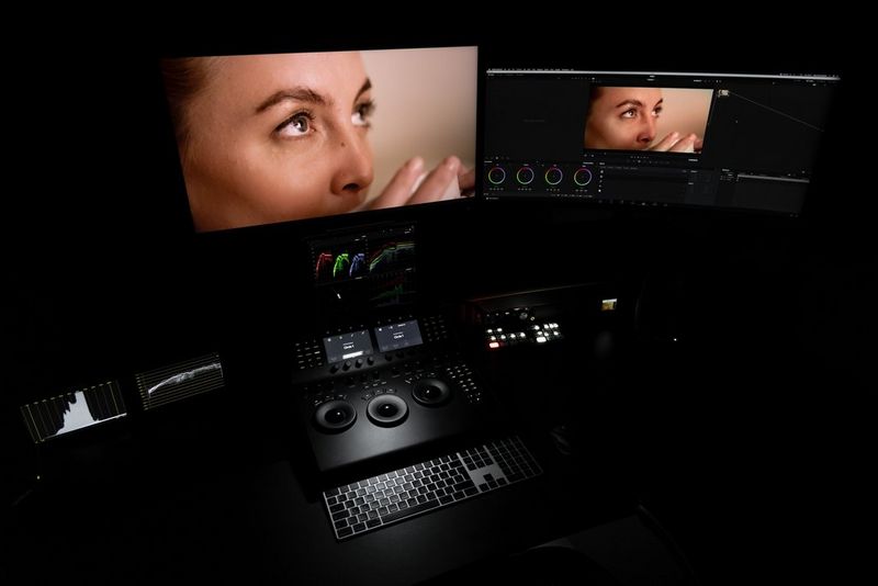 Un ordinateur dans une suite de montage vidéo avec deux écrans de référence HD.