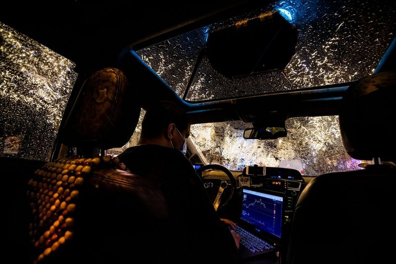 Un chauffeur de taxi français tape sur son ordinateur portable en attendant des clients pendant la pandémie de Covid-19.