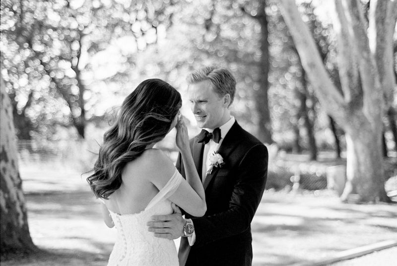 Photo en noir et blanc d'un couple le jour de leur mariage. La mariée verse une larme.