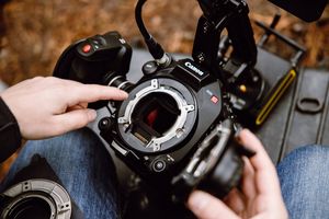 A pair of hands hold a Canon Cinema EOS camera and point to a full-frame sensor within.
