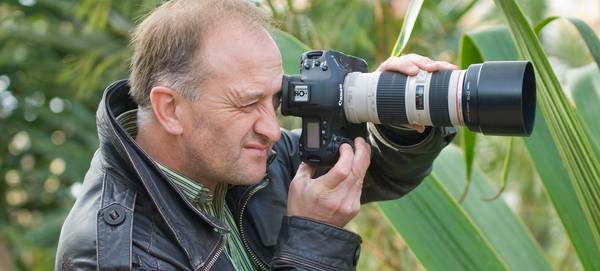 Garden photographer Clive Nichols holding a Canon camera.