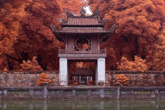 The Khuê V?n pavilion at the Temple of Literature in Hanoi, Vietnam, surrounded by trees that appear a red/orange hue due to an infrared filter.