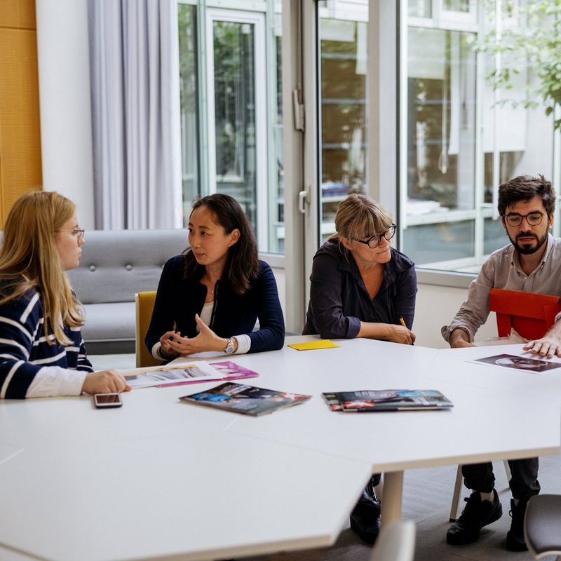Participants in the Canon Student Development programme sitting around a table with staff at the Stern magazine offices in Hamburg, Germany.