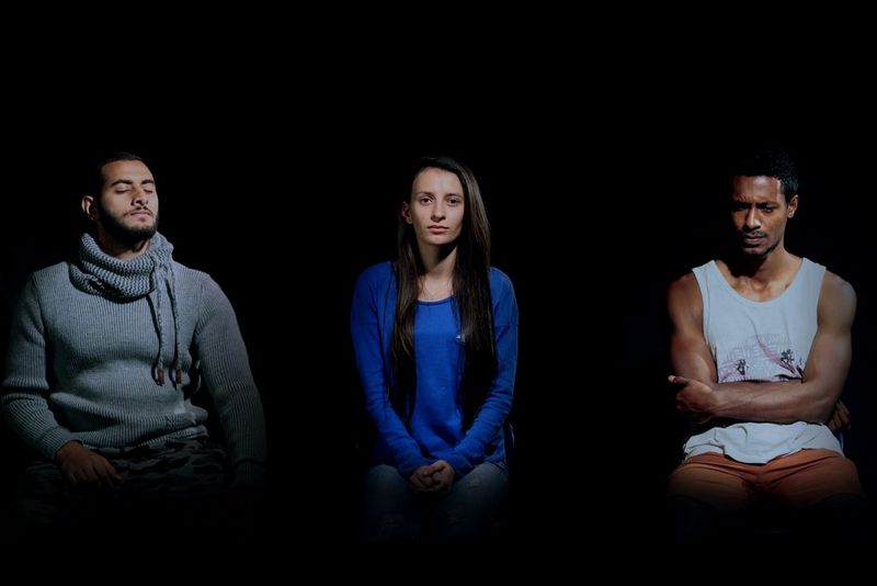 Video still of a man with his eyes closed, a woman looking neutral, and a man with arms folded, frowning. Filmed on a Canon EOS 5D Mark IV.