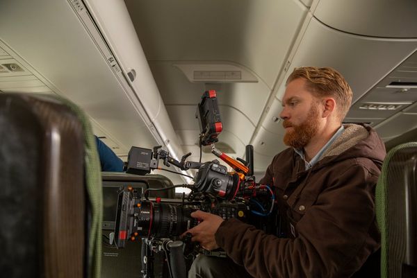 Steve Holleran filming with a Canon EOS C300 Mark III inside the cabin of an aircraft.