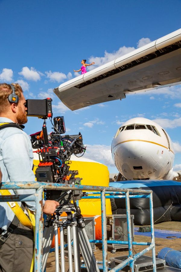 Cinematographer Steve Holleran filming with a Canon EOS C300 Mark III from the ground, looking up at the wing of an aircraft. 