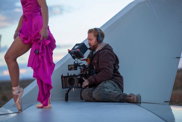 A cameraman with a Canon EOS C300 Mark III sat on the wing of an aircraft filming a ballerina dancing next to him. 