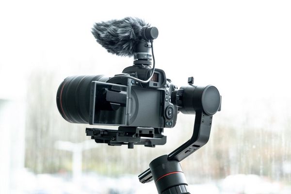 A Canon EOS R5 mounted on a filming arm mount with an external microphone.