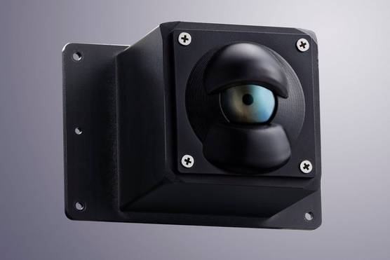 A small black box with screws at the corners has a round bulge at the front, looking like an eyeball with a pupil in the middle.